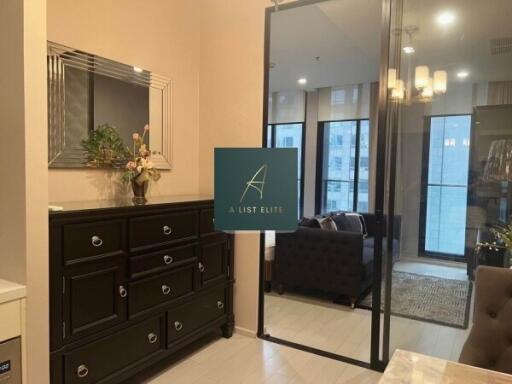 Modern living room with dresser, large mirror, and comfortable seating area