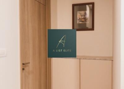 Image of an interior hallway with a closed door and a framed picture on the wall