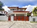 Front view of a modern house with a gated fence