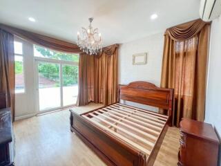 Spacious bedroom with wooden bed frame and large windows