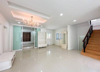 Spacious living room with chandelier and staircase