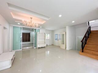 Spacious living room with chandelier and staircase