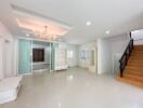 Spacious living room with chandelier and staircase