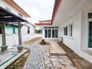 Photo of the exterior view of the property with paved walkway and glass doors