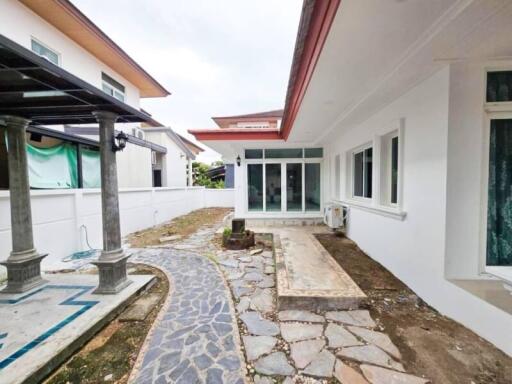 Photo of the exterior view of the property with paved walkway and glass doors