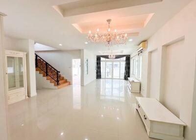 Spacious living room with chandelier and staircase