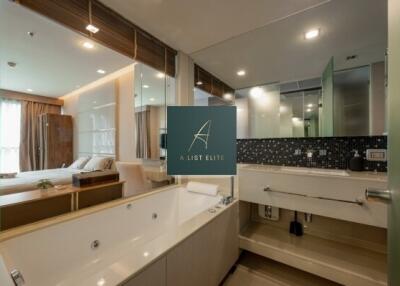 Modern bedroom with attached bathroom featuring neutral tones and natural light