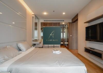 Modern bedroom with bed, television, and mirror