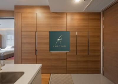 Modern kitchen with wooden cabinets and a view into the bedroom