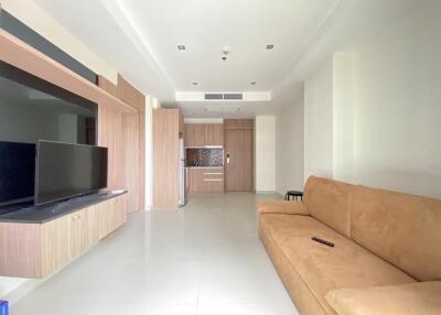 Modern living room with integrated kitchen area and beige couch