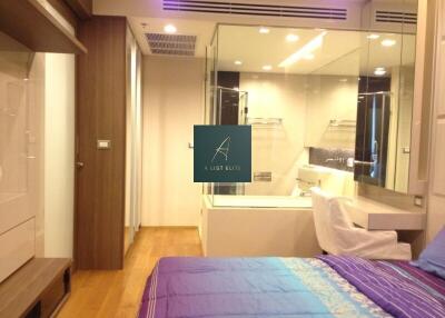 Modern bedroom with glass partition to bathroom