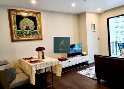 Living and dining area with a decorated wall, dining table, and TV setup