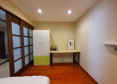 Bedroom with wooden flooring, wardrobe, desk, and sliding doors