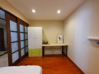 Bedroom with wooden flooring, wardrobe, desk, and sliding doors