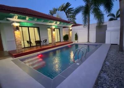 Outdoor pool area with seating and tropical landscaping