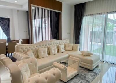 Modern living room with cream-colored furniture and large windows