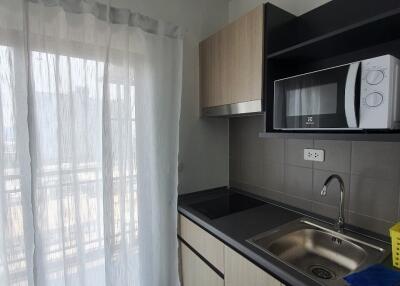 Modern kitchen with cabinetry, sink, and microwave