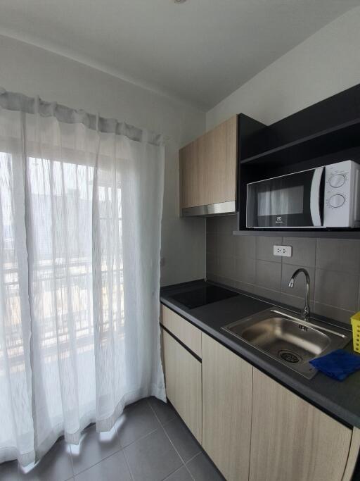 Modern kitchen with cabinetry, sink, and microwave