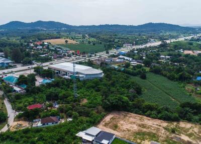 Aerial view of a residential and agricultural area with hills in the background