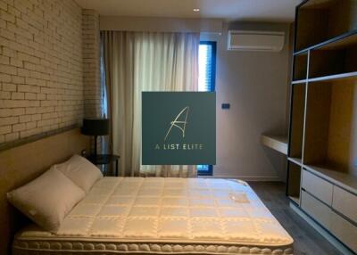 Modern bedroom with brick wall and ample storage