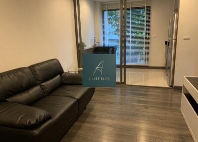 Living room with black leather couch and glass partition