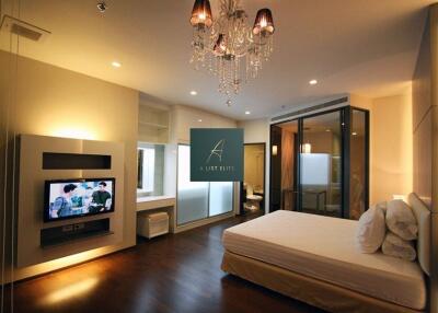 Modern bedroom with chandelier and TV