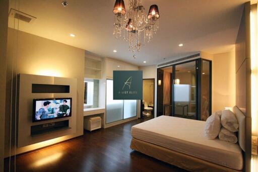 Modern bedroom with chandelier and TV