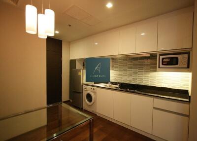 Modern kitchen with white cabinets, black countertops, and appliances