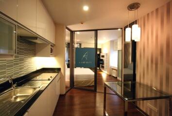 Modern kitchen and living area with glass partition and sleek design