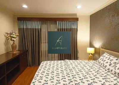 Well-decorated bedroom with patterned bedsheets and bedside lamp