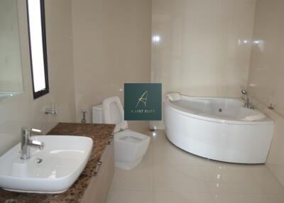 Modern bathroom with a corner bathtub and a large counter with sink