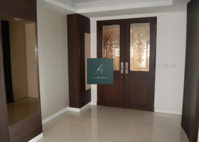 Entrance foyer with double wooden doors and a large mirror