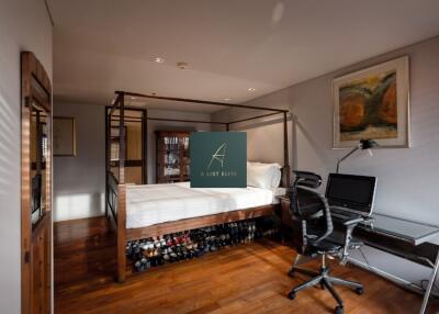 Bedroom with a four-poster bed, workstation, and wooden flooring