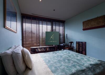 Modern bedroom with bed, window blinds, and bookshelf