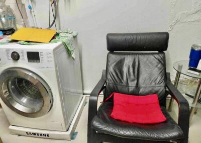 Laundry room with washing machine and chair