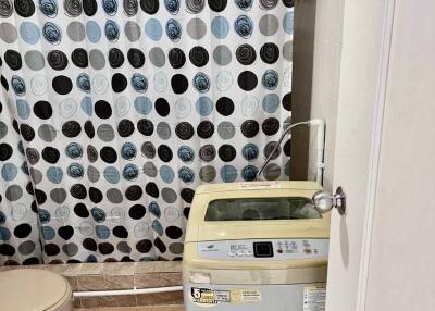 Bathroom with shower curtain and washing machine