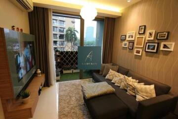 Modern living room with a sofa, TV, wall art, and a balcony view