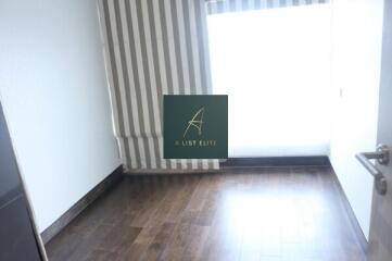 Empty bedroom with wooden flooring and striped curtains