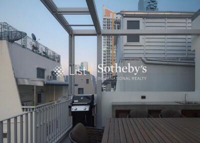 Outdoor dining area on balcony with table, chairs, and grill