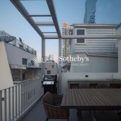 Outdoor dining area on balcony with table, chairs, and grill