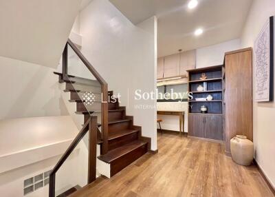 Interior view of a modern staircase area with wooden floors and built-in shelving