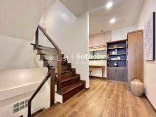 Interior view of a modern staircase area with wooden floors and built-in shelving