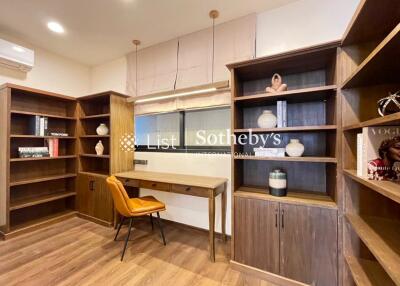 Home office with built-in wooden shelves, desk, and chair