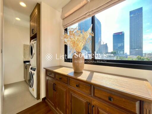 Bright utility room with a view, featuring wooden cabinets and in-unit laundry machines