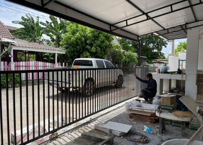 A covered outdoor area with a view of a pickup truck and garden