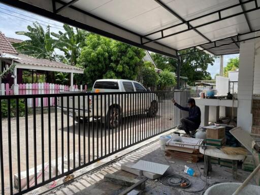 A covered outdoor area with a view of a pickup truck and garden