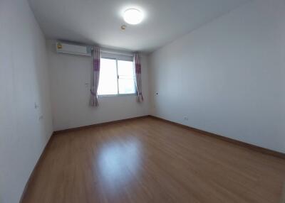 Empty bedroom with wooden flooring and large window