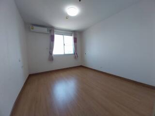 Empty bedroom with wooden flooring and large window