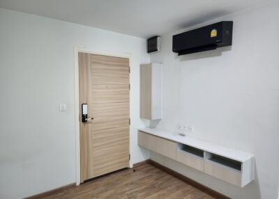 Main living space with door, air conditioning unit, and storage cabinets