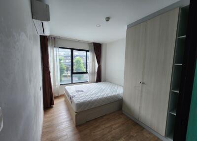 Spacious bedroom with large window, bed, and wardrobe